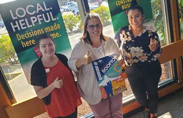 Michelle, Toni and Nancy pose for a photo while holding a poster promoting the Bridge Music Project's upcoming concert