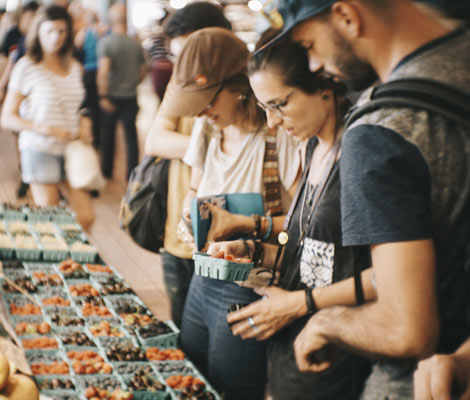 people looking at produce at a farmers market