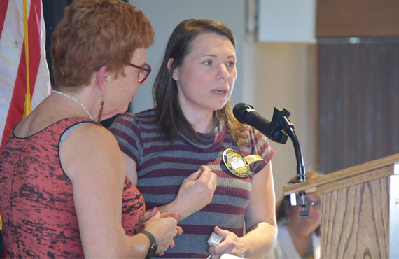 Carol Duris speaks into a microphone at Rotary #8 event