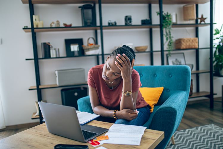 Woman stressed out in front of a laptop.