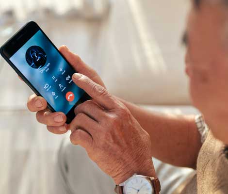 senior citizen receives a scam phone call on their smartphone