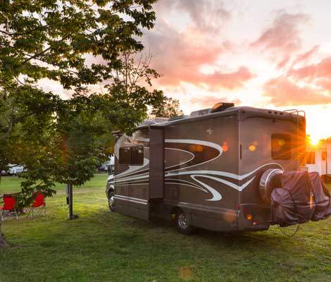 RV parked at a campsite at sunset