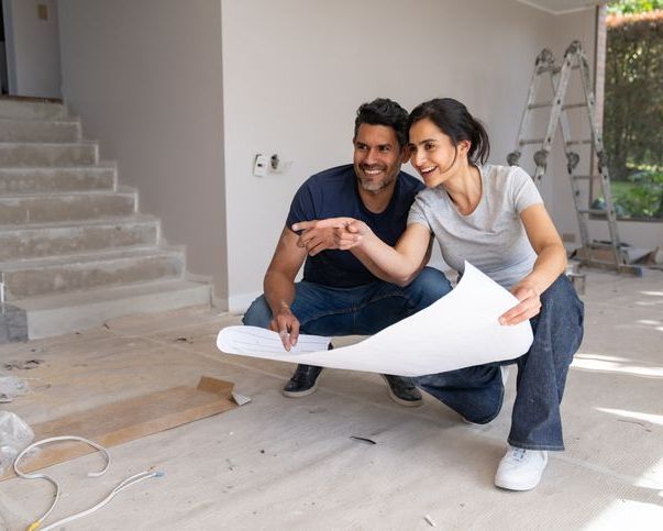 Couple looking at blueprints for home renovation