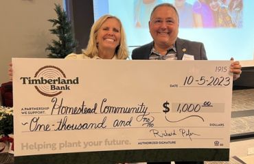 Richard Pifer presents a check to the Homestead Community.