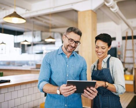 Man with tablet talking to small business owner
