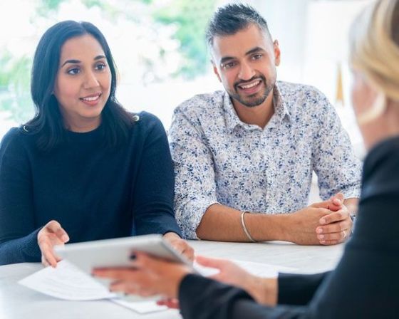 Couple sitting at desk with loan officer