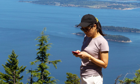 woman on a hike looking at her phone