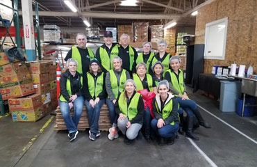 Timberland Bank employees pose for a photo during a repackaging event at a local food bank
