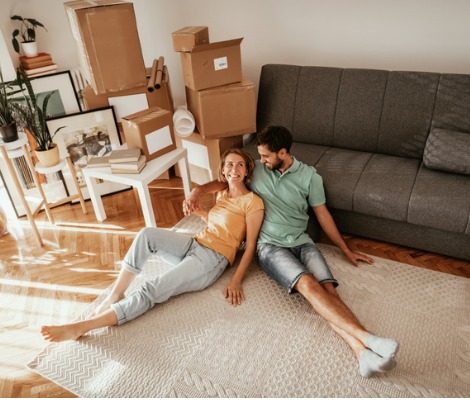 family sitting on floor moving into a new apartment