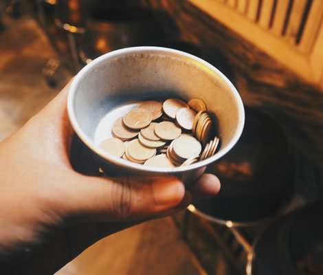 person holding a cup of change
