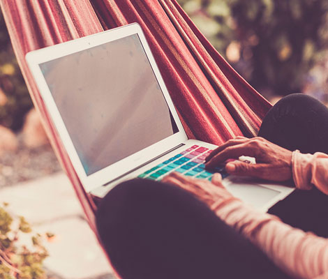 person in a hammock on a laptop