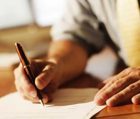 close up of hands signing a contract with a pen