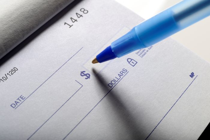 Close-up of a pen writing on a check. 