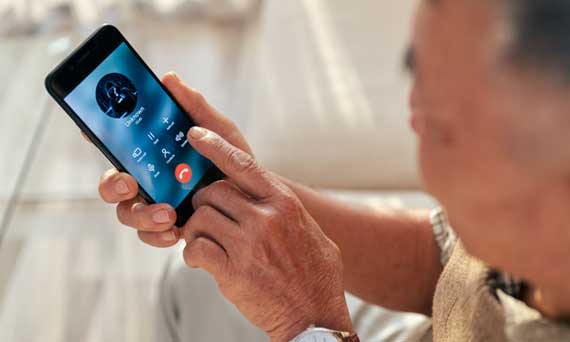 senior citizen receives a scam phone call on their smartphone