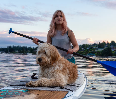 woman on a paddleboard with her dog