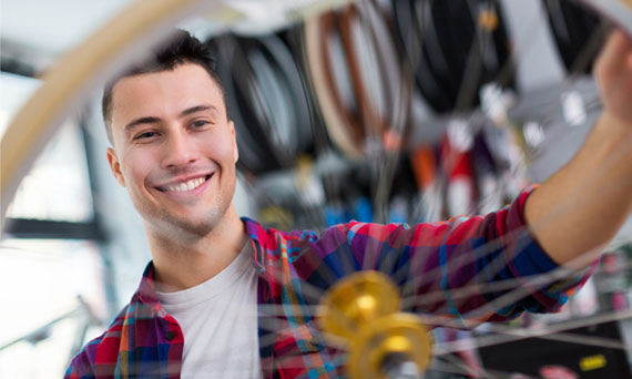 employee in flannel fixes bike tire