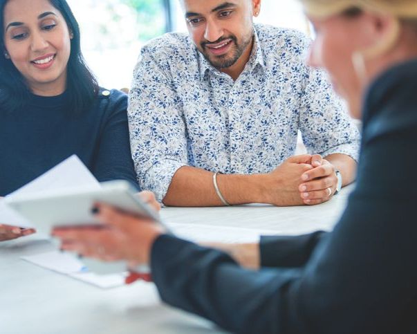 Couple sitting at desk looking at papers
